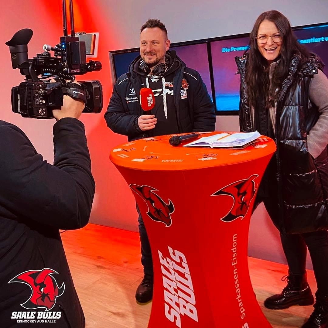 Saltan Gindulin mit Saale-Bulls-Mikrofon im Interview vor laufender Kamera